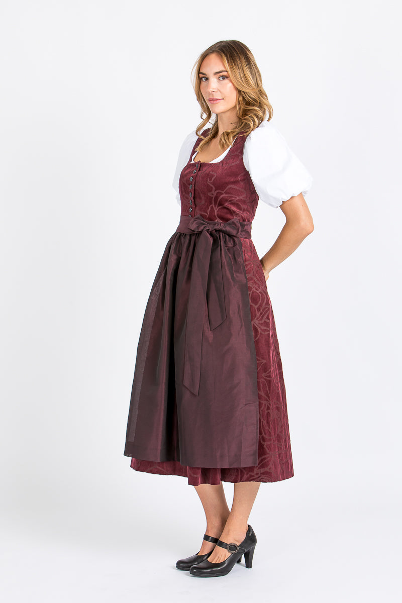 Almliebe Dirndl Loni in bordeaux in der Seitenansicht. Hier sieht man, dass der Stoff des Dirndl durchgängig ist