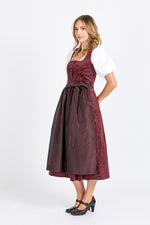Almliebe Dirndl Loni in bordeaux in der Seitenansicht. Hier sieht man, dass der Stoff des Dirndl durchgängig ist