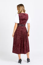 Almliebe Dirndl Loni in bordeaux in der Rückenansicht. HIer sieht man, dass das Dirndl durchgängig ist und man sieht das florale Muster.