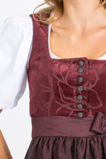 Almliebe Dirndl Loni in bordeaux in der Detailansicht. Hier sieht man den edlen Cord und das florale Muster.