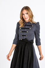 Almliebe Dirndl im Uniform-Stil in dunkelblau mit schwarzer Schürze. Frontansicht. 