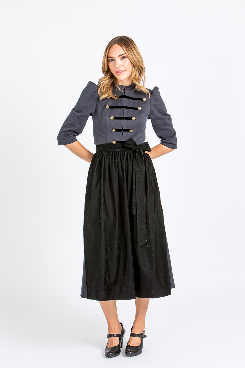Almliebe Dirndl im Uniform-Stil in dunkelblau mit schwarzer Schürze. Frontansicht. 