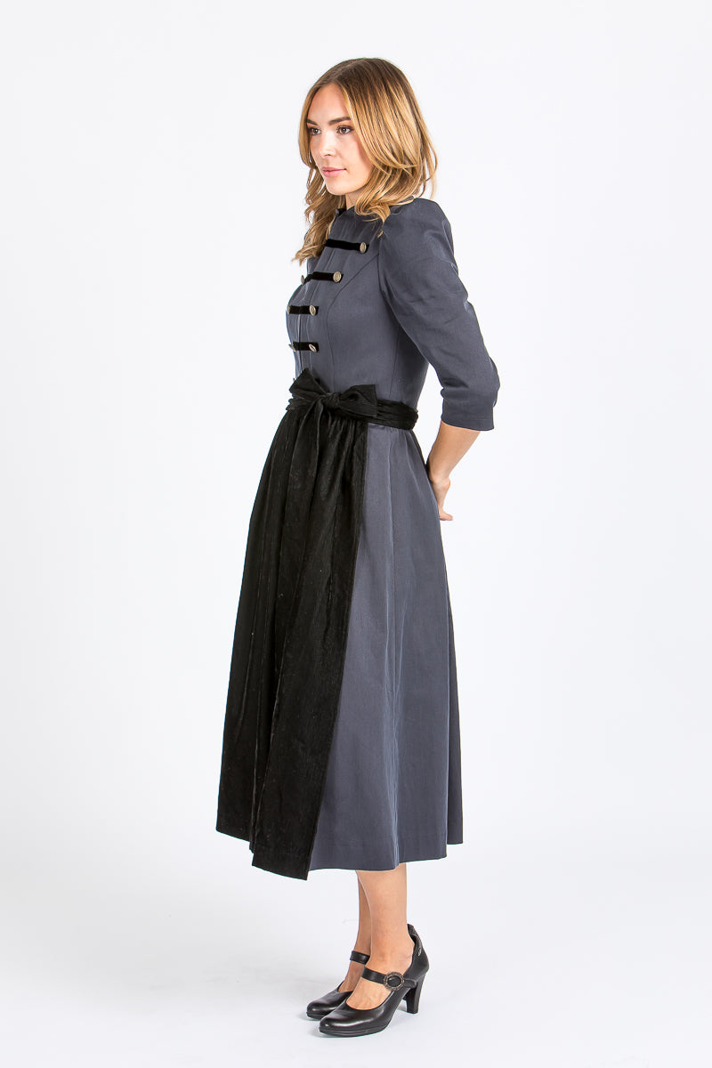 Almliebe Dirndl im Uniform-Stil in dunkelblau mit schwarzer Schürze. Seitenansicht. 