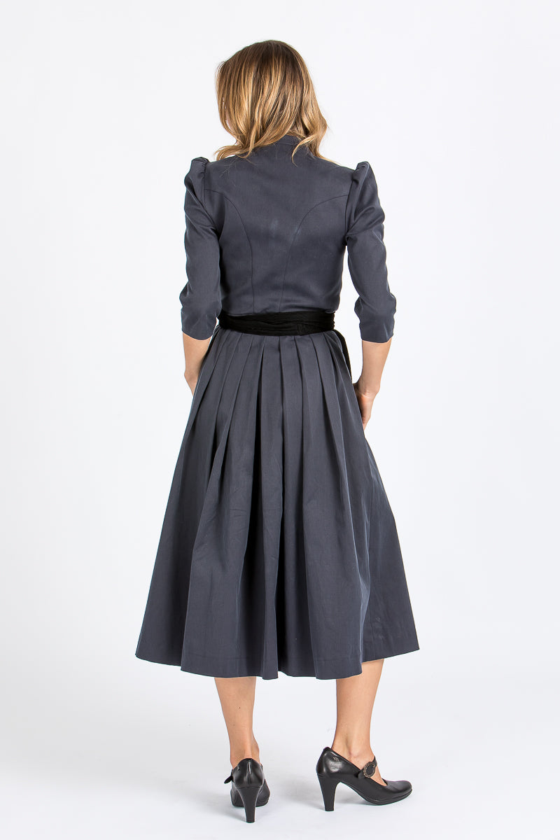 Almliebe Dirndl im Uniform-Stil in dunkelblau mit schwarzer Schürze. Rückenansicht. 