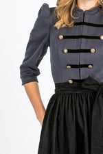 Almliebe Dirndl im Uniform-Stil in dunkelblau mit schwarzer Schürze. Detailansicht. 