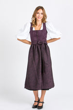 Alpenherz Dirndlbluse Daphne aus Baumwolle mit Puffarm und V-Ausschnitt unter einem violetten Dirndl in Ganzkörperansicht